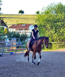 Tanja reitet ein Pferd im Freien